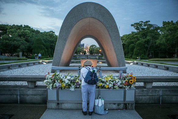 A woman pays respects at the arch inside the Peace Memorial Park in Hiroshima, Japan.