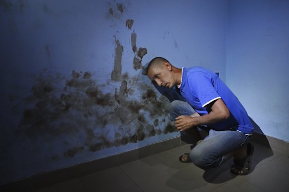 Olekdsndr Fayizov, a civilian computer technician demonstrates where Russian soldiers beat his head against the wall of a room used as a cell in the basement of the Trostyanets railway station in Ukraine.