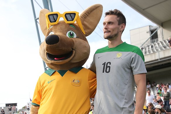 James Holland, pictured with Maloo the Socceroos mascot, in 2014.
