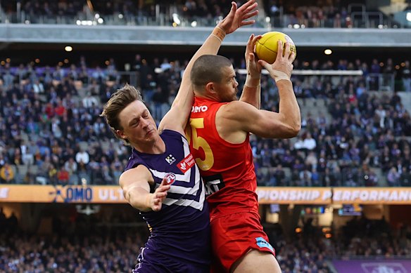 Sam Collins of the Suns marks the ball against Jye Amiss of the Dockers.