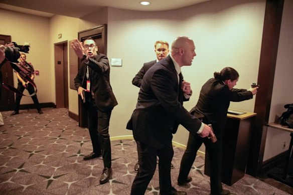 Secret Service members draw their weapons in response to the gunshots.