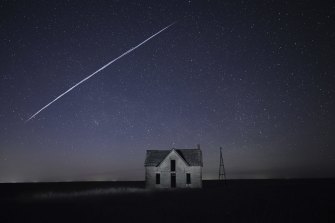 Une chaîne de satellites SpaceX StarLink passe au-dessus d'une vieille maison en pierre près de Florence, Kan. Le train de lumières était en fait une série de satellites volant relativement bas lancés par SpaceX d'Elon Musk dans le cadre de son service Internet Starlink.