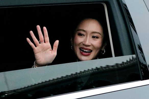 Paetongtarn Shinawatra waves as she leaves Government House in Bangkok after being dismissed as prime minister last Friday.