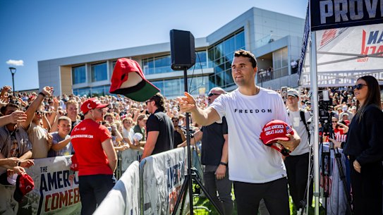 Charlie Kirk hands out hats before he was shot and killed at Utah Valley University on Wednesday.