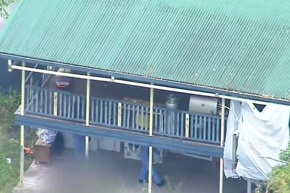 Police examine the house at Buccan, south of Brisbane, where a woman was found dead, with a man arrested over the NSW border in Kempsey.