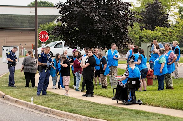 Police speak to employees of Walmart after the attack.