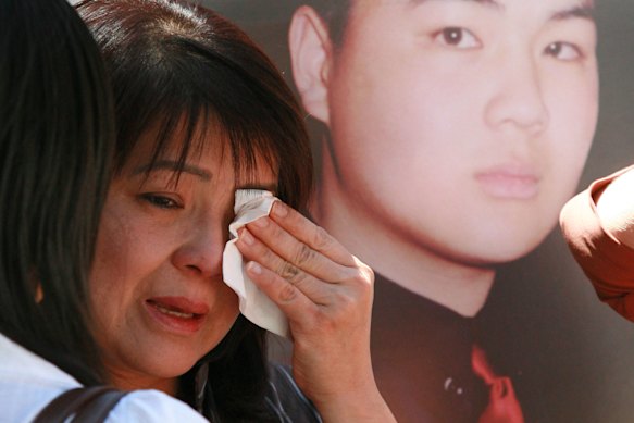 Kim Nguyen weeps in front of a poster of her son, Van Nguyen, in 2006, one year after her son was executed.