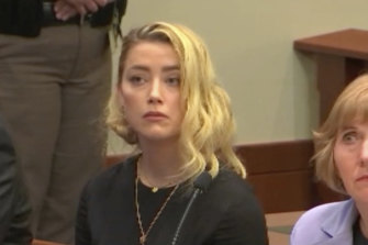 Dans cette capture d'écran de la vidéo, Amber Heard, au centre, et ses avocats Elaine Bredehoft, à droite, et Ben Rottenborn, à gauche, réagissent à la lecture du verdict.