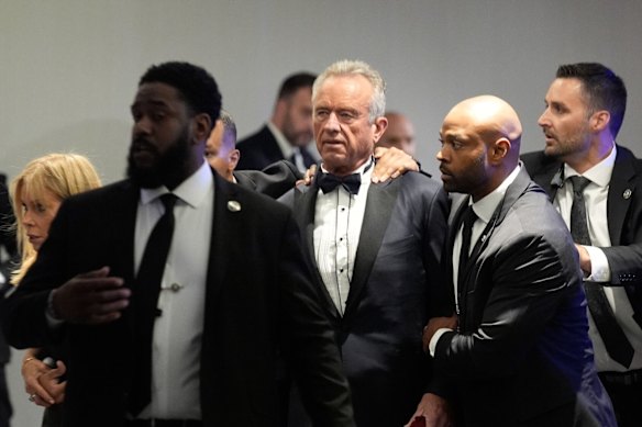US secretary of Health and Human Services Robert F. Kennedy Jr. is escorted from the ballroom.