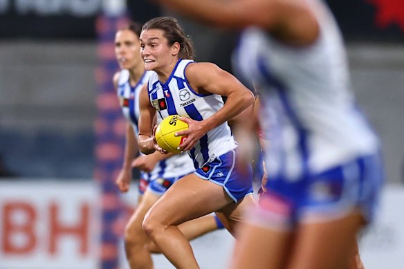 Ash Riddell of the Kangaroos runs with the ball.
