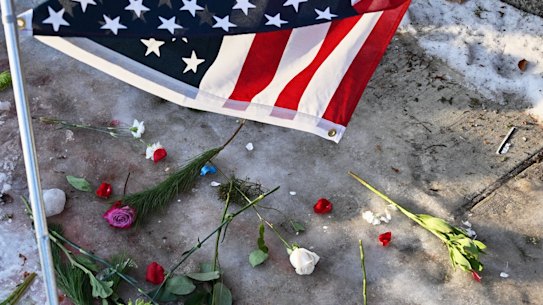 Flowers and candles are placed as protesters gather near the scene of the fatal shooting.