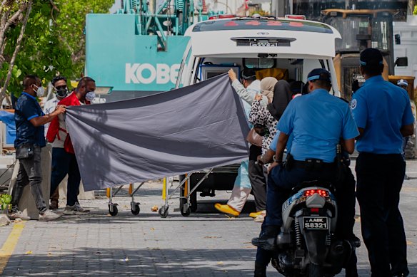 Health workers carry the recovered bodies of two of the four Italians who died deep inside an underwater cave.