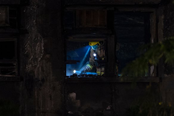 A firefighter searches through a building.