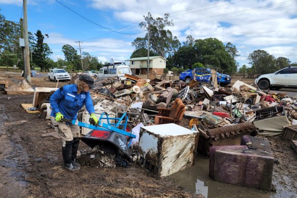A Disaster Relief Australia volunteer helps clear debris after the Lismore floods in 2022. 