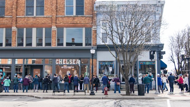 In this photo provided by Burrill Strong, supporters of Serendipity Books help move the entire shop stock to a new premises a block away in Chelsea, Michigan.