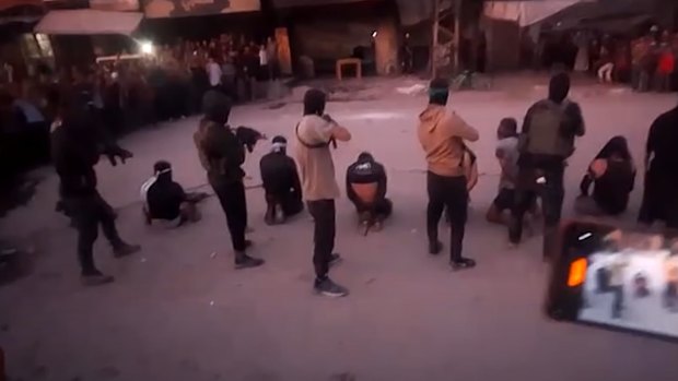 A screenshot from a video posted by Reuters that purported to show Hamas fighters executing men alleged to be Israeli collaborators on a Gaza City street.