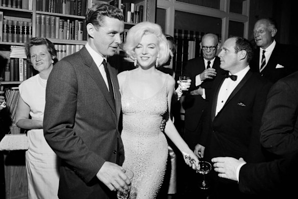 In this May 19, 1962 photo provided by the John F. Kennedy Presidential Library and Museum, actress Marilyn Monroe wears the iconic gown that she wore while singing “Happy Birthday” to President John F. Kennedy at Madison Square Garden, during a reception in New York City. Standing next to Monroe is Steve Smith, President Kennedy’s brother-in-law. 