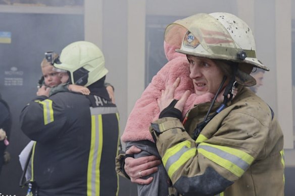In this photo provided by the Ukrainian Emergency Service, rescuers evacuate children from the kindergarten.