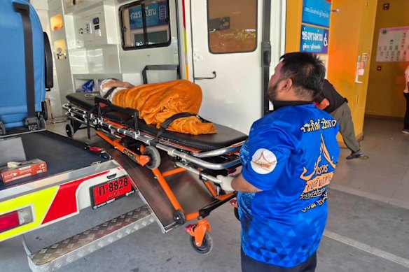 An emergency services worker with the woman who was found to be alive after being considered dead.