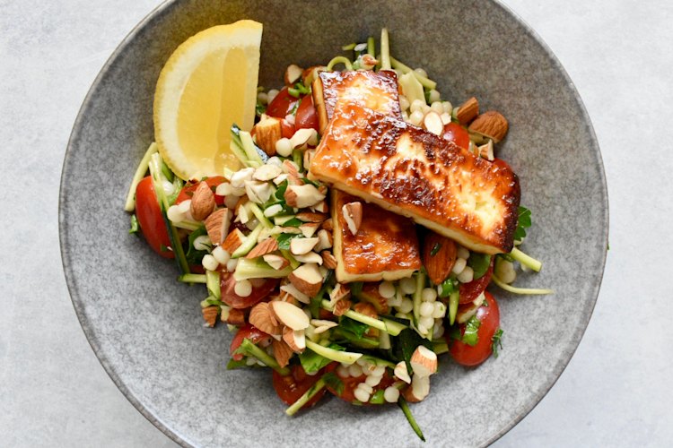 Simple ingredients star in this salad, which tops pearl cous cous, zucchini and almonds with halloumi.
