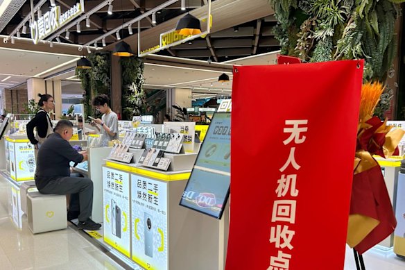 A man negotiates the sale of his drone at an official buy-back retailer in Beijing ahead of a citywide ban on drones coming into effect on November 15. 