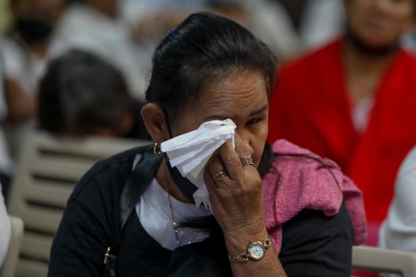 A woman wipes away tears in Manila on Monday night.