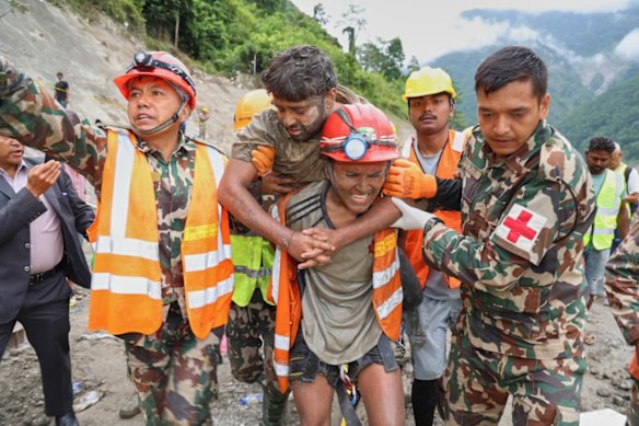 Sanjay Sah, a mechanical foreman, was carried out on the back of a worker to a rescue tent, his face covered in mud.