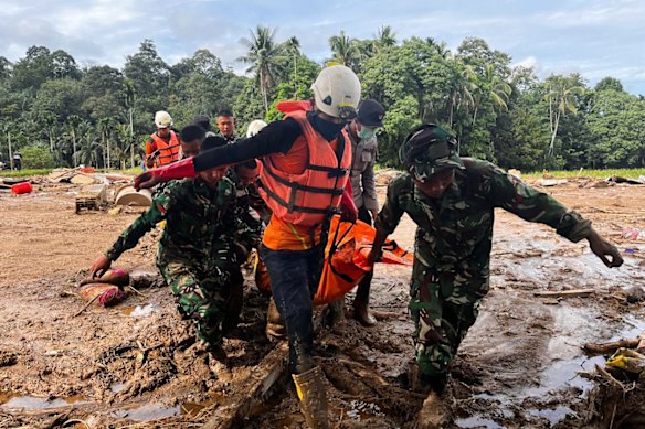 Rescuers carry the body of a flood victim, in Agam, West Sumatra, Indonesia, on Sunday.