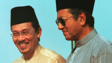 1998年，左翼的安瓦尔·易卜拉欣站在马来西亚总理马哈蒂尔的旁边。