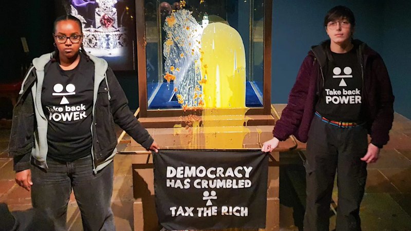 “Tax the rich” activists attack Tower of London display with crumble and custard