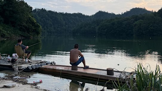 Local villagers fish from the reservoir in Xingming village.