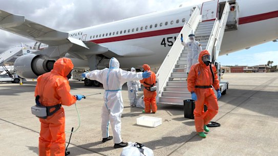 A Spanish passenger is sprayed with disinfectant by Spanish government officials before boarding a plane after disembarking from the hantavirus-stricken cruise ship on Sunday.