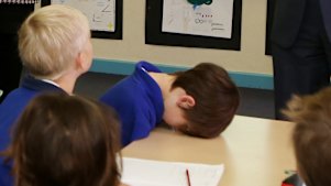 A student takes a rest when then-Prime Minister Tony Abbott makes a school visit.