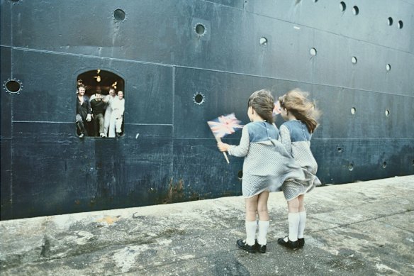 Two girls see off 3500 soldiers from Southampton, England, on board the Queen Elizabeth 2, requisitioned for the Falklands War, in May 1982.