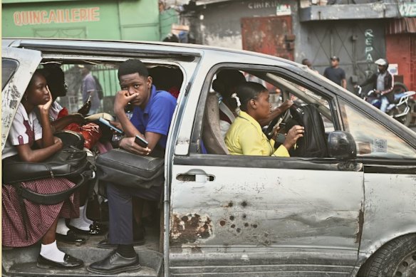 Passengers ride in a shared taxi as it makes its way through Port-au-Prince, Haiti in March 2026.  