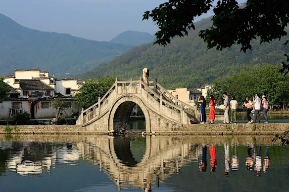 Crossed by four hump-backed bridges, Moon Pond lies in the heart of the Chinese water village of Hongcun.