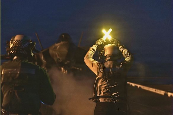 US servicemen guide an F-35 stealth fighter as it prepares to launch from the flight deck of aircraft carrier USS Abraham Lincoln during Operation Epic Fury on March 2.  