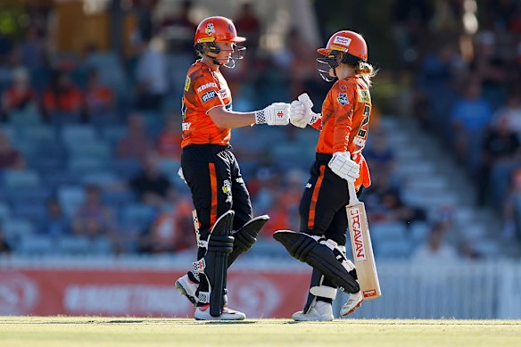 Katie Mack and Beth Mooney celebrate a 100-run opening partnership for the Perth Scorchers.