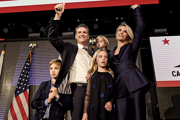 Newsom and his wife, Jennifer Siebel Newsom, on stage with their children, wave to supporters on gubernatorial election night in 2018. 