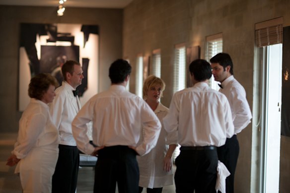 Mallory Wall (rear) briefs waiters before service at Cafe Di Stasio.