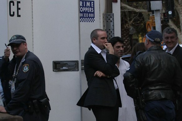 Julian Morrow and Chas Licciardello  are detained by the police at APEC.