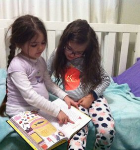 Liliana and Sabrina reading together, aged 5 and 8.
