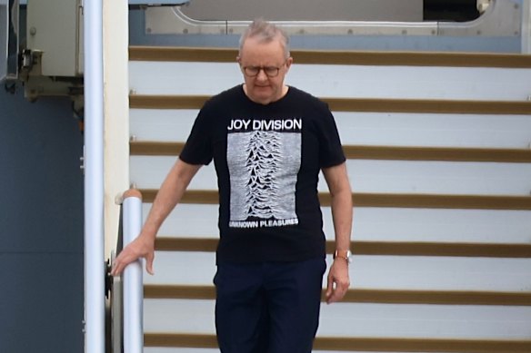 Anthony Albanese disembarks from the RAAF plane in the Joy Division t-shirt last Thursday.
