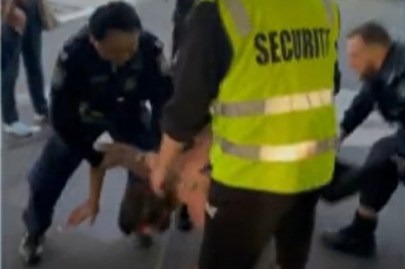 Police apprehend a man on the street after he allegedly assaulted an officer during a pub brawl. 