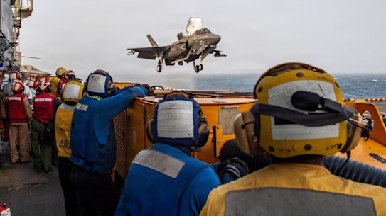An image released by US Central Command shows service members aboard the amphibious assault ship USS Boxer supporting flight operations from the Arabian Sea.