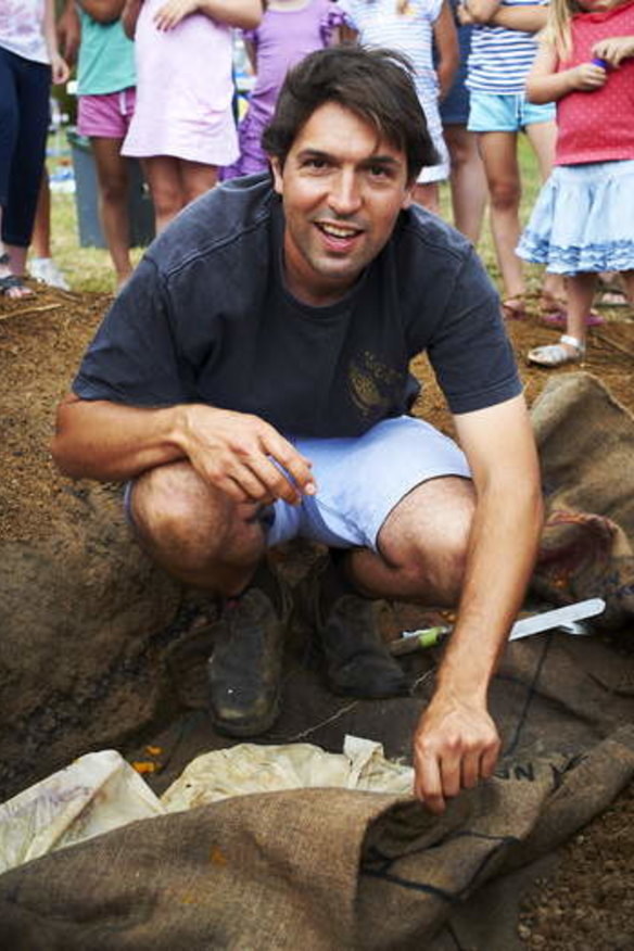 A young Ben Shewry poses for the camera with an underground pit oven.