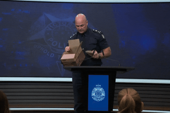 Commander Wayne Cheeseman tips out a box of rocks that were hurled at officers.