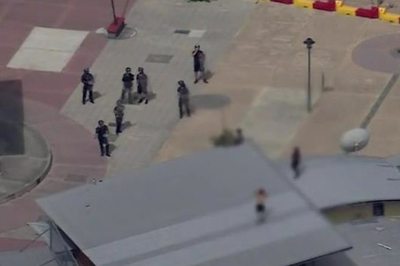 Detention centre officers watch on from the ground, wearing riot gear as the juveniles threw projectiles at them from the roof.