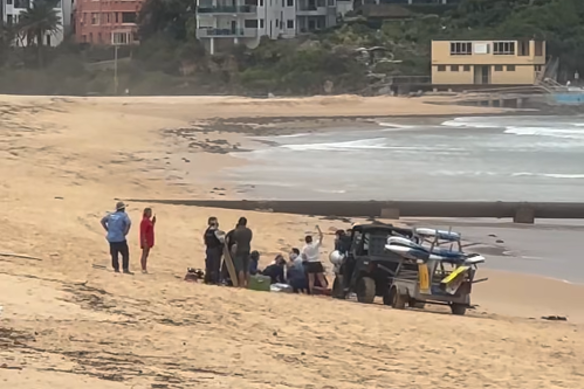 First responders tend to the man bitten by a shark at Manly.