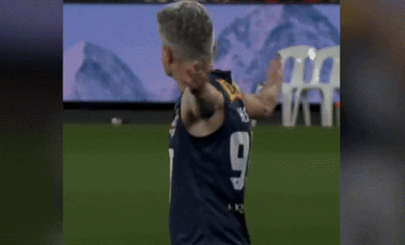 Dave Hughes gets pushed over after kicking a goal in the Legends game.